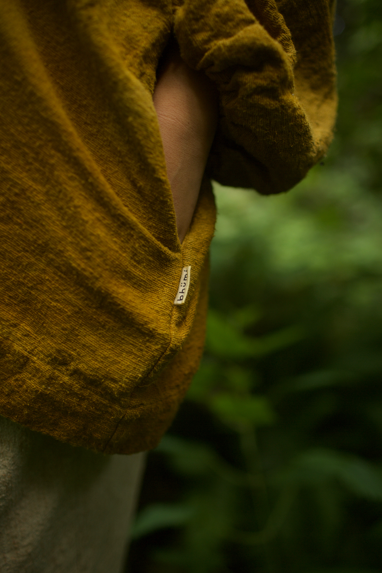 Close-up of a mustard-dyed garment with the bhümi label